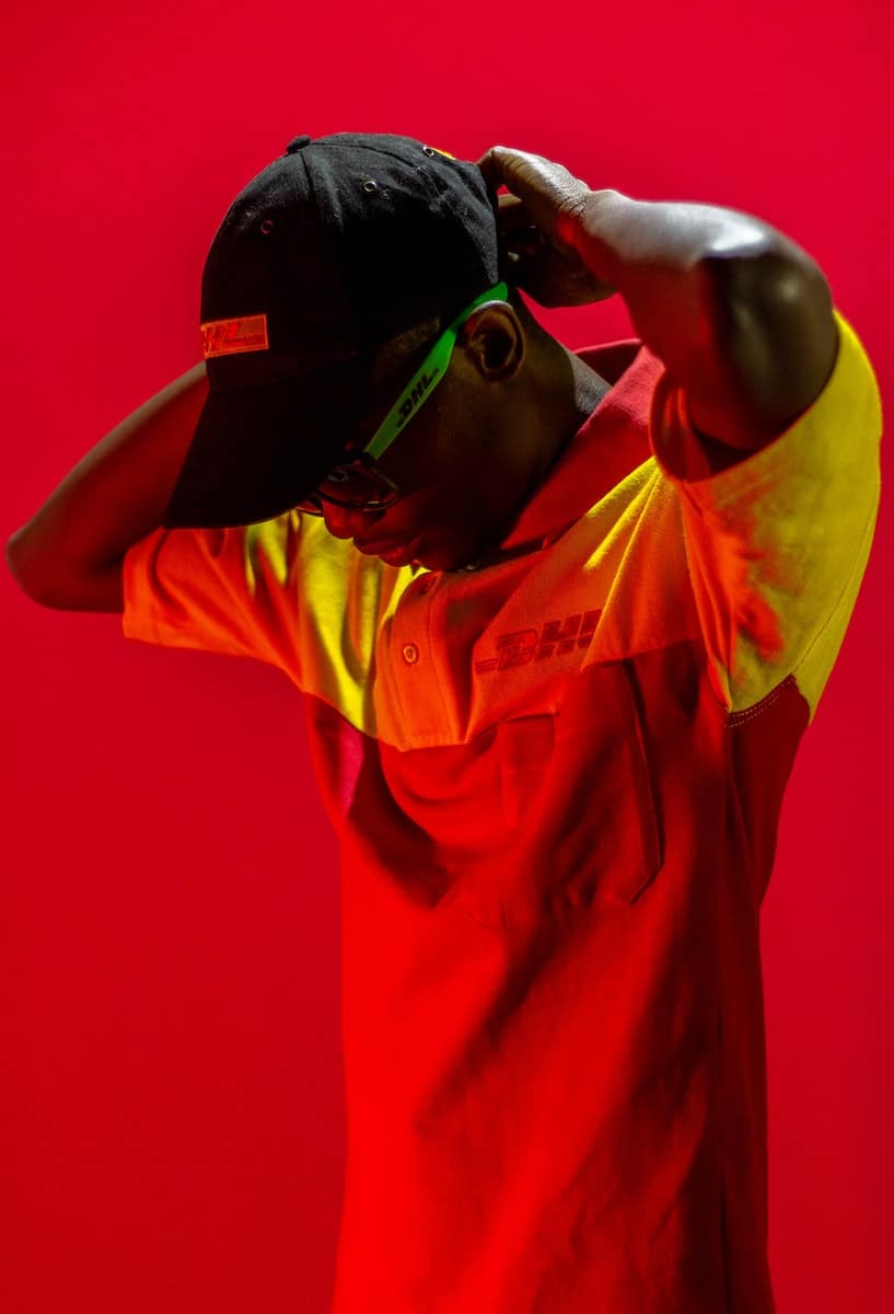 Man Dressed in DHL Clothes Posing in Red Lighting 