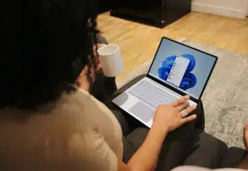 Female on her Microsoft laptop at work drinking coffee