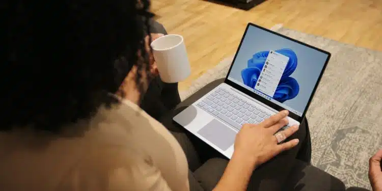 Female on her Microsoft laptop at work drinking coffee